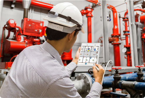 Technician inspecting pipework and equipment using a tablet